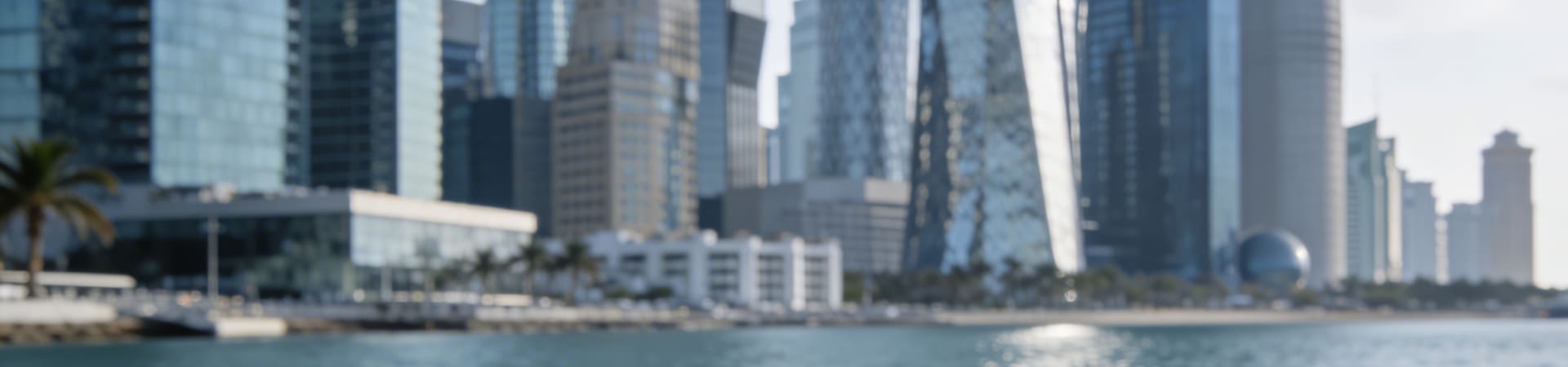 Modern glass skyscrapers reflecting a clear sky